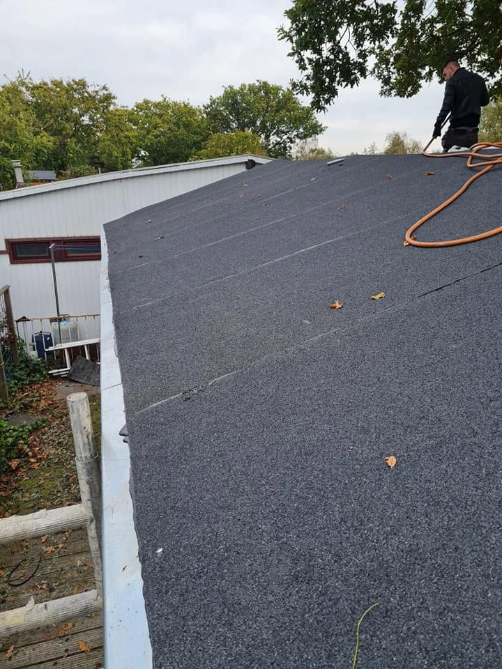 Dakdekker brengt nieuwe bitumen dakbedekking aan op een plat dak