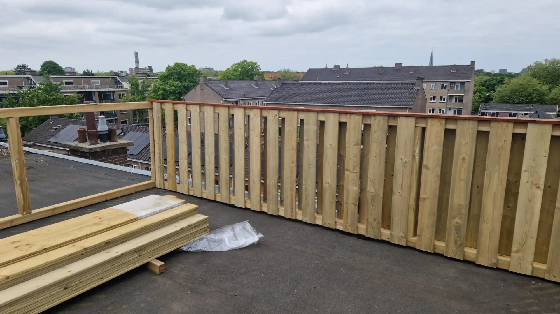 Nieuwe houten schutting met hardhouten afdeklat op een dakterras